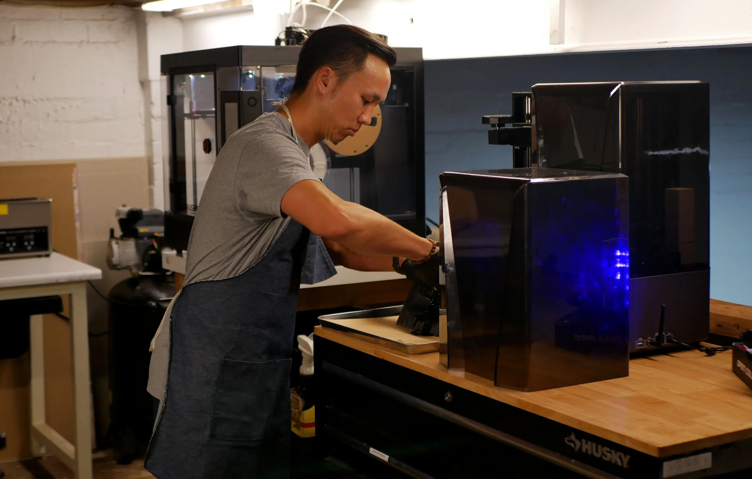 A person working with a 3D printer in a workshop.